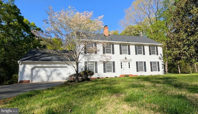 13086 Langley Rd, Bryantown, MD 20617 - colonial-style house featuring driveway, a chimney, a front lawn, and a garage