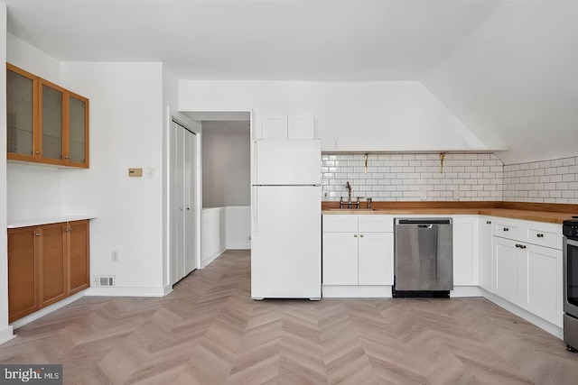 kitchen with freestanding refrigerator, white cabinetry, dishwasher, and a sink