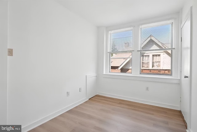 empty room with light wood-style flooring and baseboards