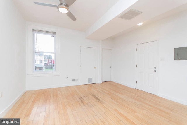 empty room featuring light wood-type flooring, baseboards, and visible vents