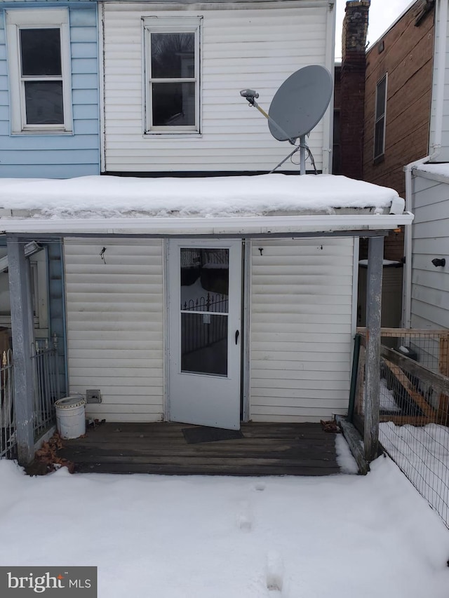 snow covered property with fence and a wooden deck