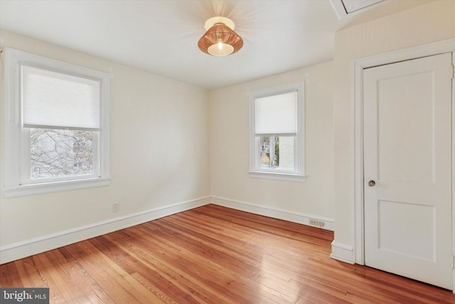 spare room featuring light wood-style flooring and baseboards