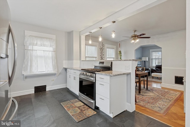 kitchen featuring stainless steel appliances, a peninsula, visible vents, and white cabinets