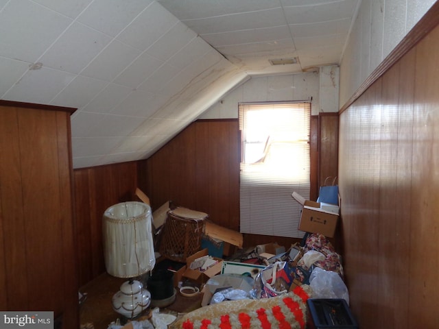 additional living space with lofted ceiling and wooden walls