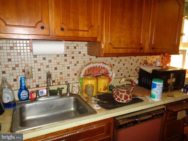 kitchen with decorative backsplash, light countertops, a sink, and dishwasher