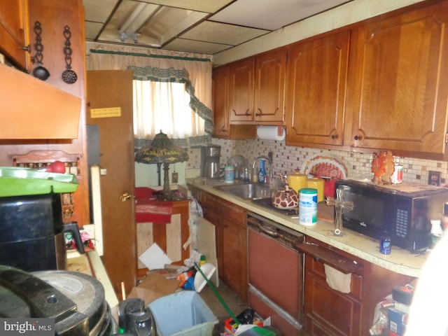 kitchen featuring light countertops, decorative backsplash, a sink, black microwave, and dishwasher