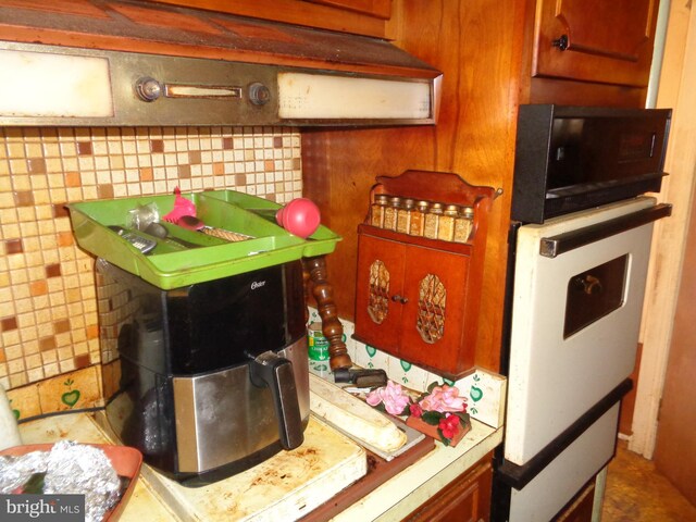 kitchen with brown cabinetry, light countertops, and oven