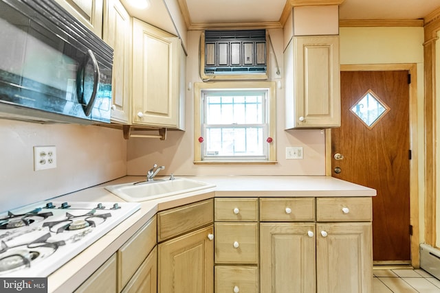 kitchen with crown molding, white gas stovetop, light countertops, a sink, and black microwave