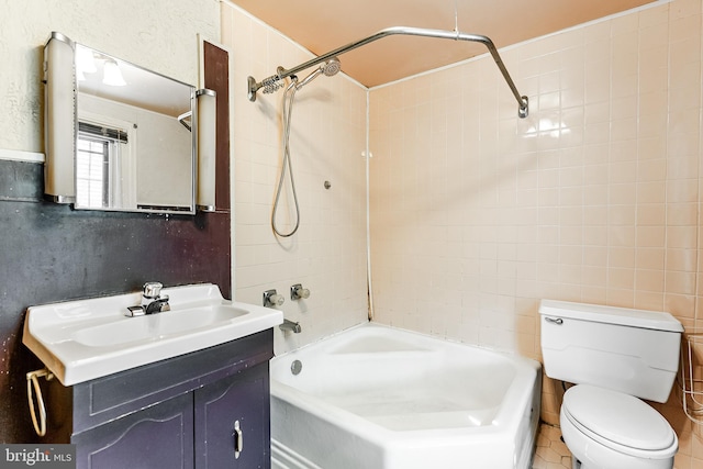 full bath with a textured wall, bathing tub / shower combination, vanity, and toilet