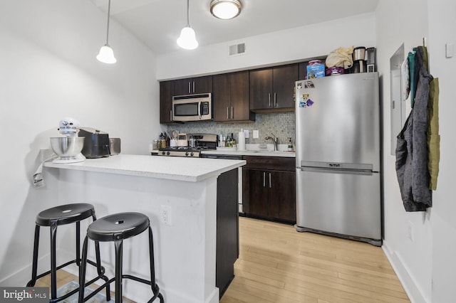 kitchen with visible vents, appliances with stainless steel finishes, backsplash, and dark brown cabinetry