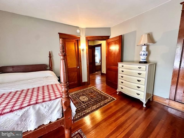 bedroom featuring baseboards and dark wood finished floors