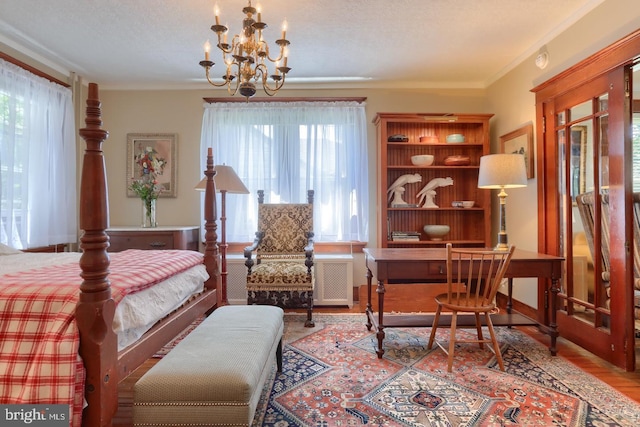 bedroom featuring a chandelier, a textured ceiling, wood finished floors, and crown molding