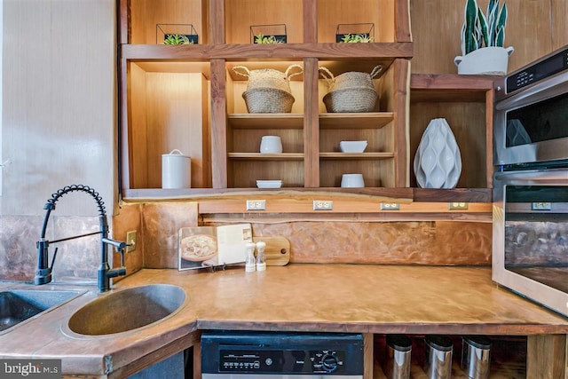 room details featuring dishwashing machine, double oven, and a sink