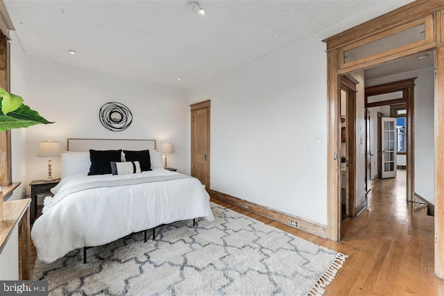 bedroom featuring light wood-style floors and baseboards