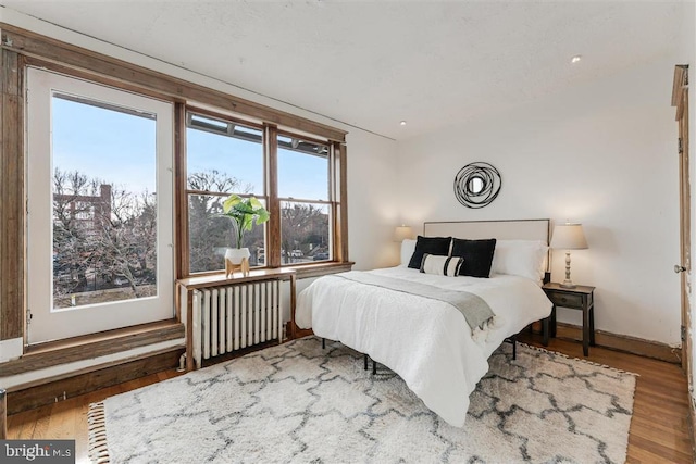 bedroom featuring radiator and wood finished floors