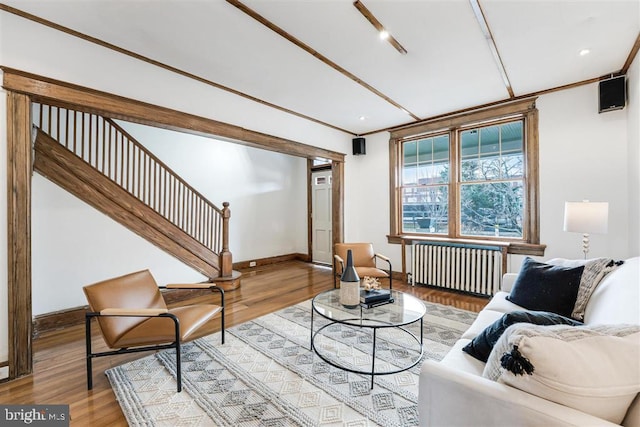 living room with baseboards, stairway, wood finished floors, and radiator