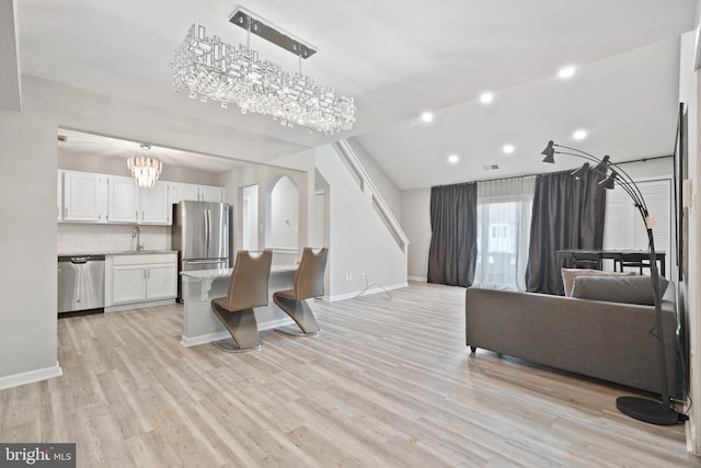 living room with arched walkways, recessed lighting, visible vents, light wood-style floors, and baseboards