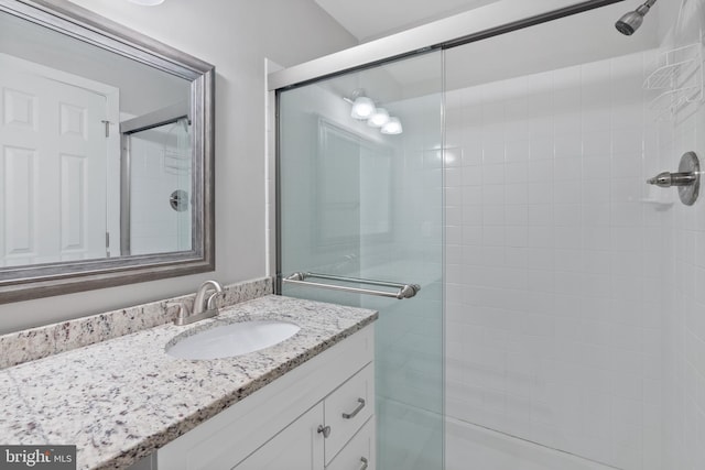 bathroom featuring a tile shower and vanity