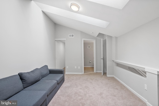 living room with lofted ceiling with skylight, light carpet, visible vents, and baseboards