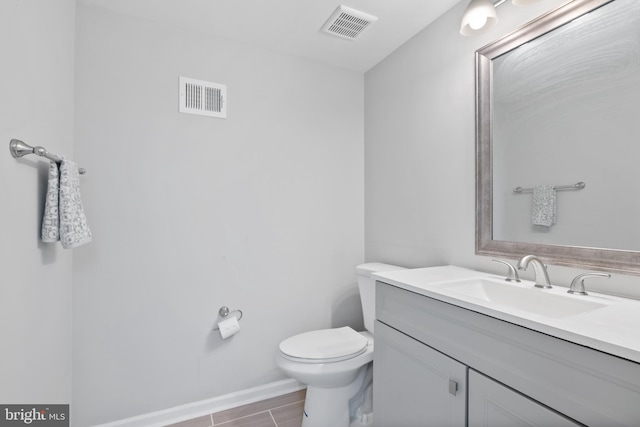 bathroom featuring baseboards, visible vents, vanity, and toilet