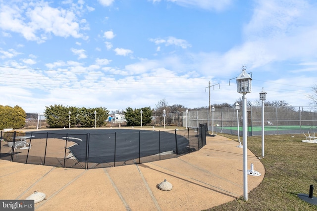 view of swimming pool featuring community basketball court and fence