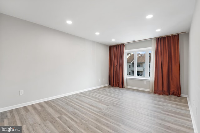 spare room featuring baseboards, recessed lighting, and light wood-style floors