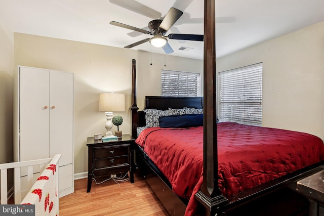 bedroom with a ceiling fan, visible vents, and wood finished floors