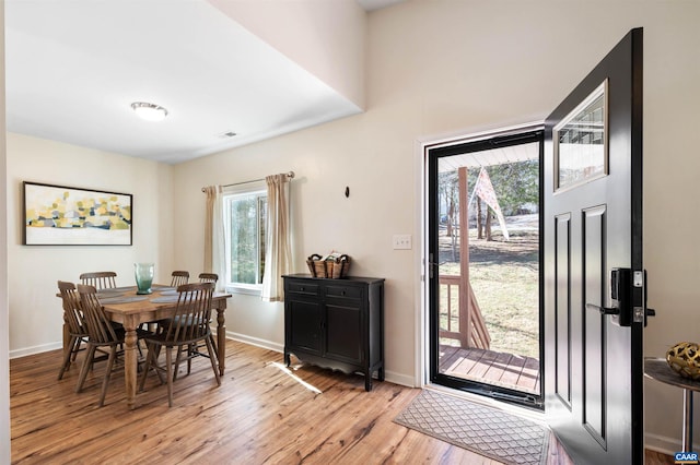 dining space with light wood-style flooring and baseboards