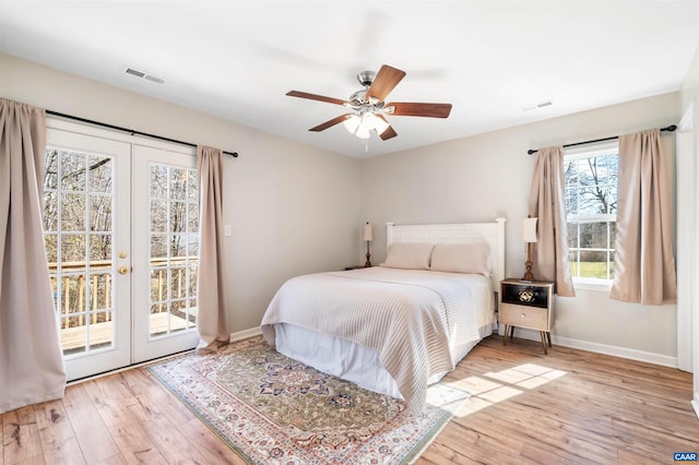 bedroom featuring access to exterior, french doors, visible vents, and wood finished floors