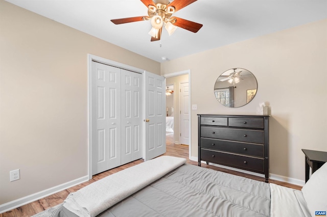 bedroom featuring ceiling fan, a closet, wood finished floors, and baseboards