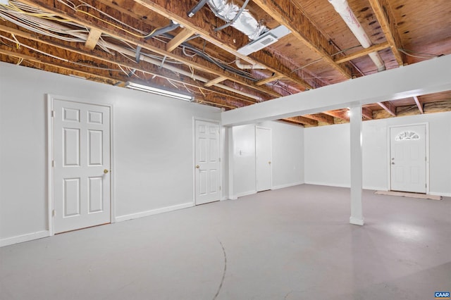 unfinished basement featuring visible vents and baseboards