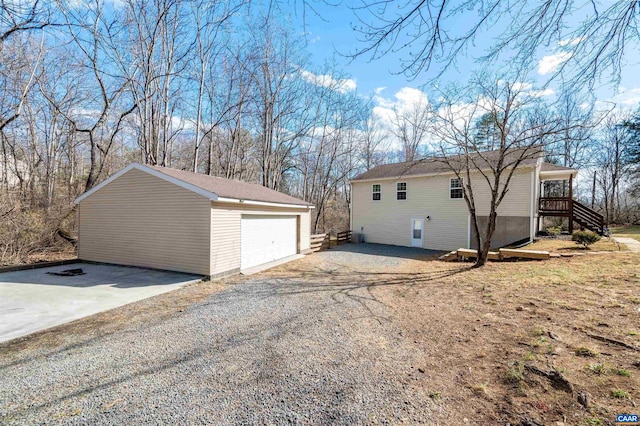 view of side of property with a garage, stairway, and an outdoor structure