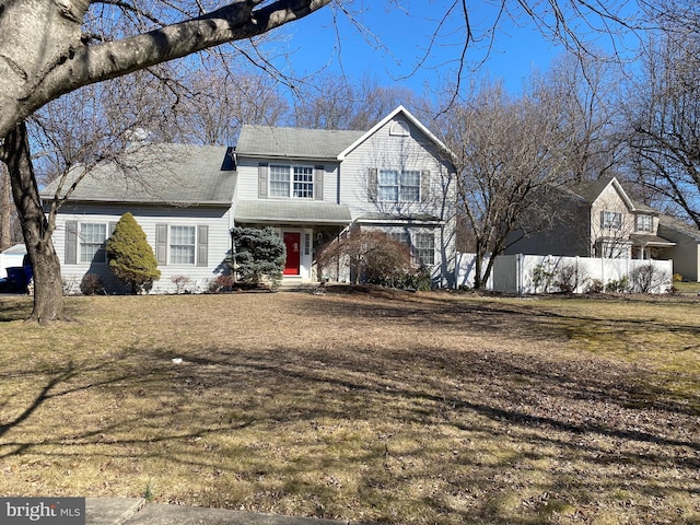 view of front of home featuring fence and a front lawn