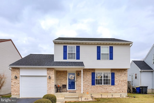 view of front facade featuring brick siding, aphalt driveway, a front yard, roof with shingles, and a garage