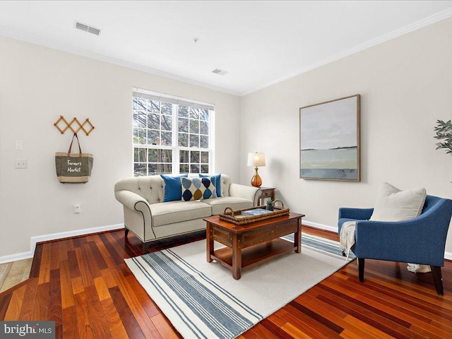 living room with visible vents, ornamental molding, baseboards, and hardwood / wood-style flooring