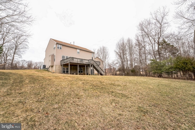 back of property featuring central air condition unit, stairs, a deck, and a lawn