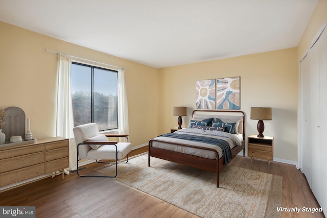 bedroom featuring a closet, baseboards, and wood finished floors