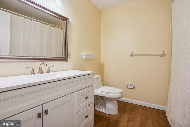 full bathroom with baseboards, vanity, toilet, and wood finished floors