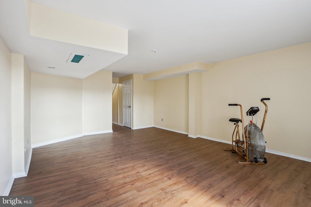 spare room with baseboards and wood finished floors