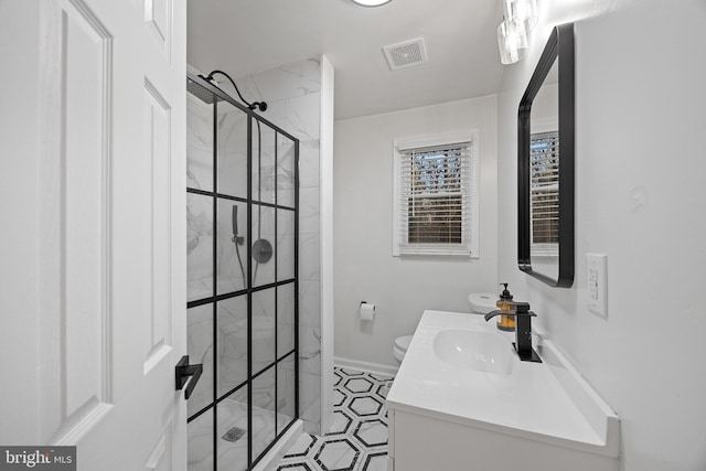 full bath featuring toilet, vanity, visible vents, baseboards, and a shower stall