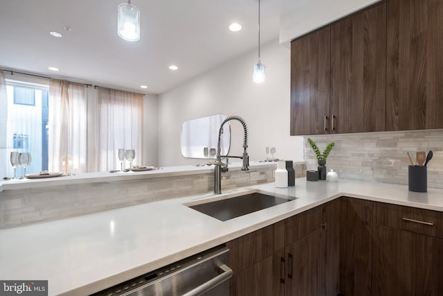 kitchen featuring light countertops, a sink, dark brown cabinets, and modern cabinets