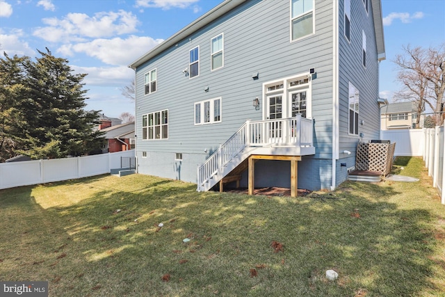 rear view of house with a lawn and a fenced backyard