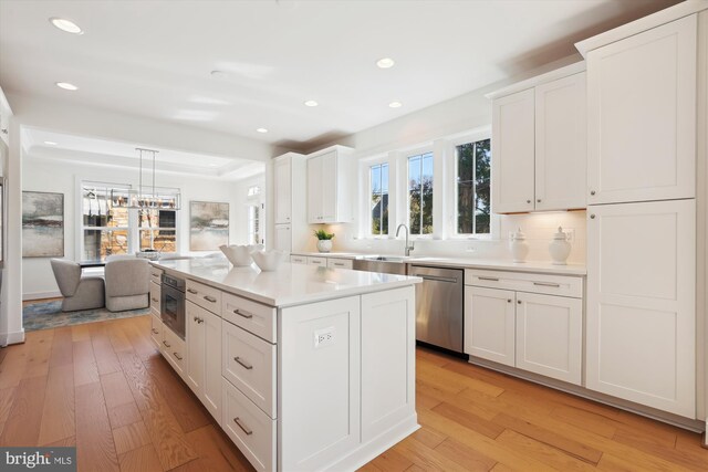 kitchen featuring dishwasher, light countertops, and light wood finished floors