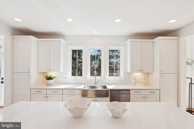 kitchen featuring recessed lighting, white cabinets, light countertops, and a sink