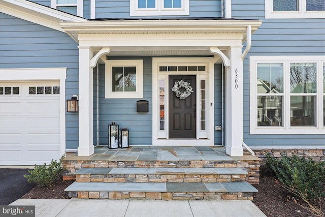 entrance to property with a garage and covered porch