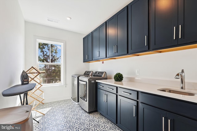 laundry room with visible vents, a sink, washer and dryer, cabinet space, and light tile patterned floors