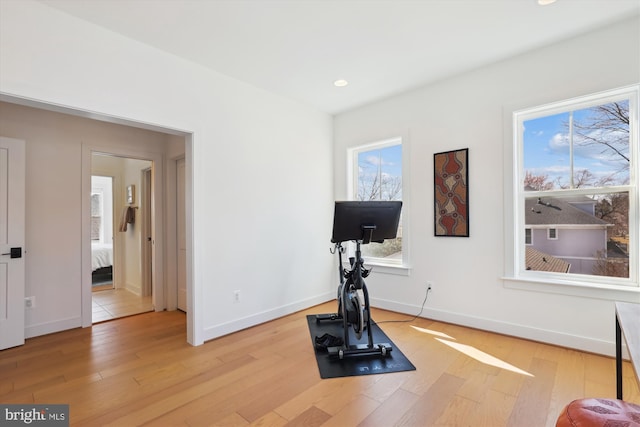 workout room featuring recessed lighting, light wood-type flooring, and baseboards