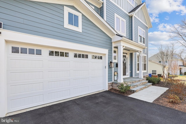 view of front facade featuring aphalt driveway, an attached garage, and board and batten siding