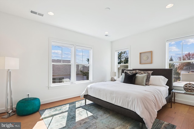 bedroom featuring recessed lighting, visible vents, multiple windows, and wood finished floors