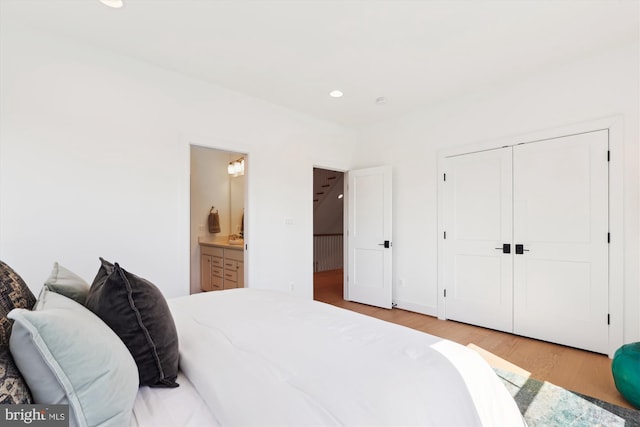 bedroom featuring a closet, recessed lighting, ensuite bathroom, and light wood-type flooring